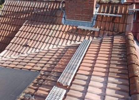 Ein Ziegeldach mit einer Metallleiter darauf