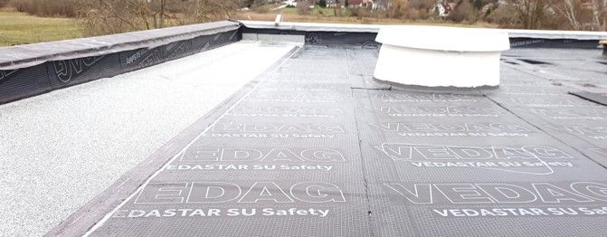 Ein schwarzes Dach mit einem weißen Schornstein darauf.