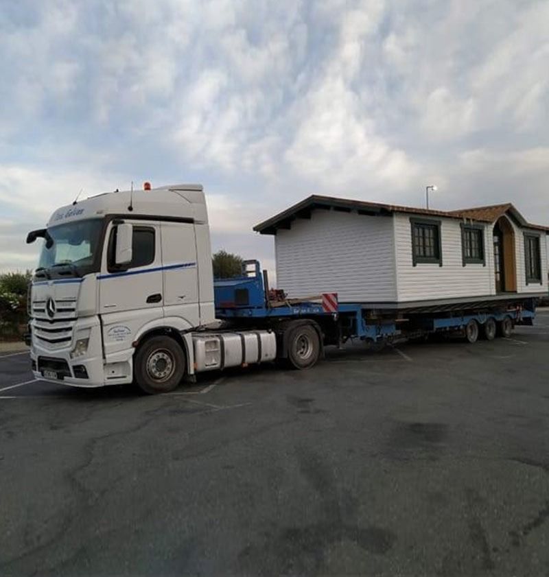 Una grúa está levantando un contenedor hacia un edificio.