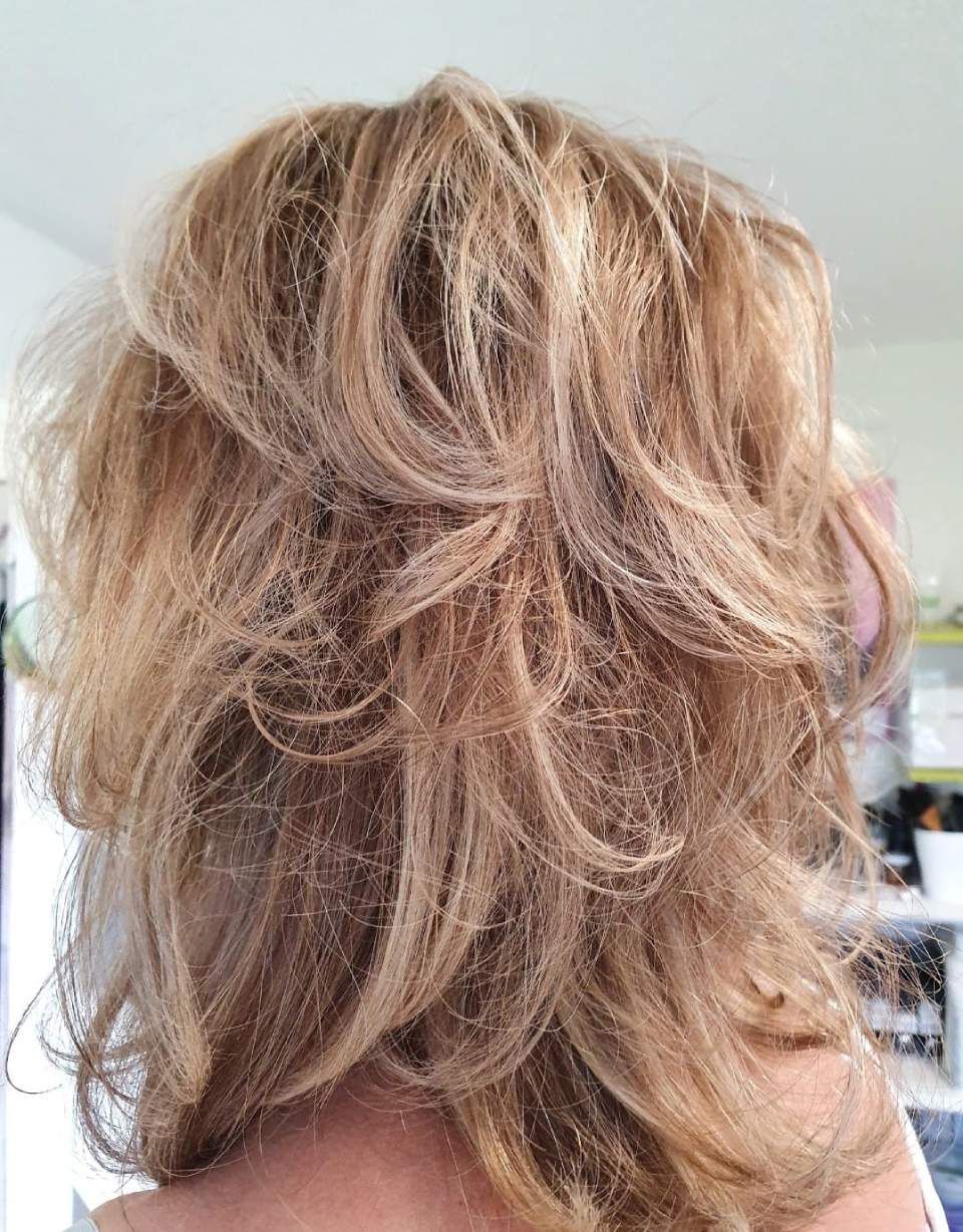 Blondes, gestuftes Haar, unordentlich und strukturiert, möglicherweise gestylt, erscheint im natürlichen Licht.