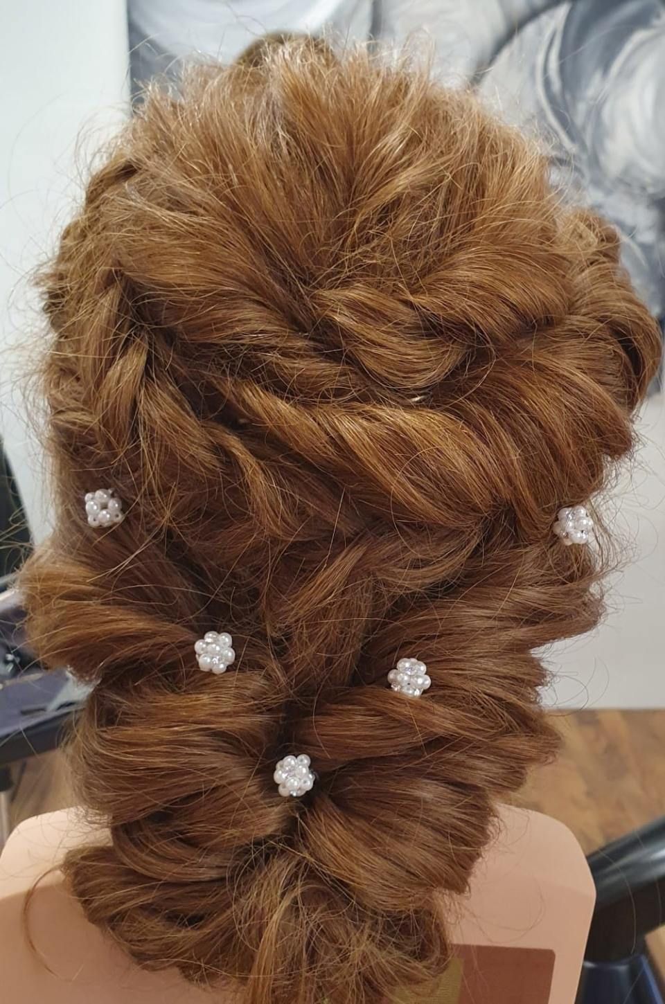 Geflochtene Hochsteckfrisur mit kleinen weissen Blumenhaarspangen.