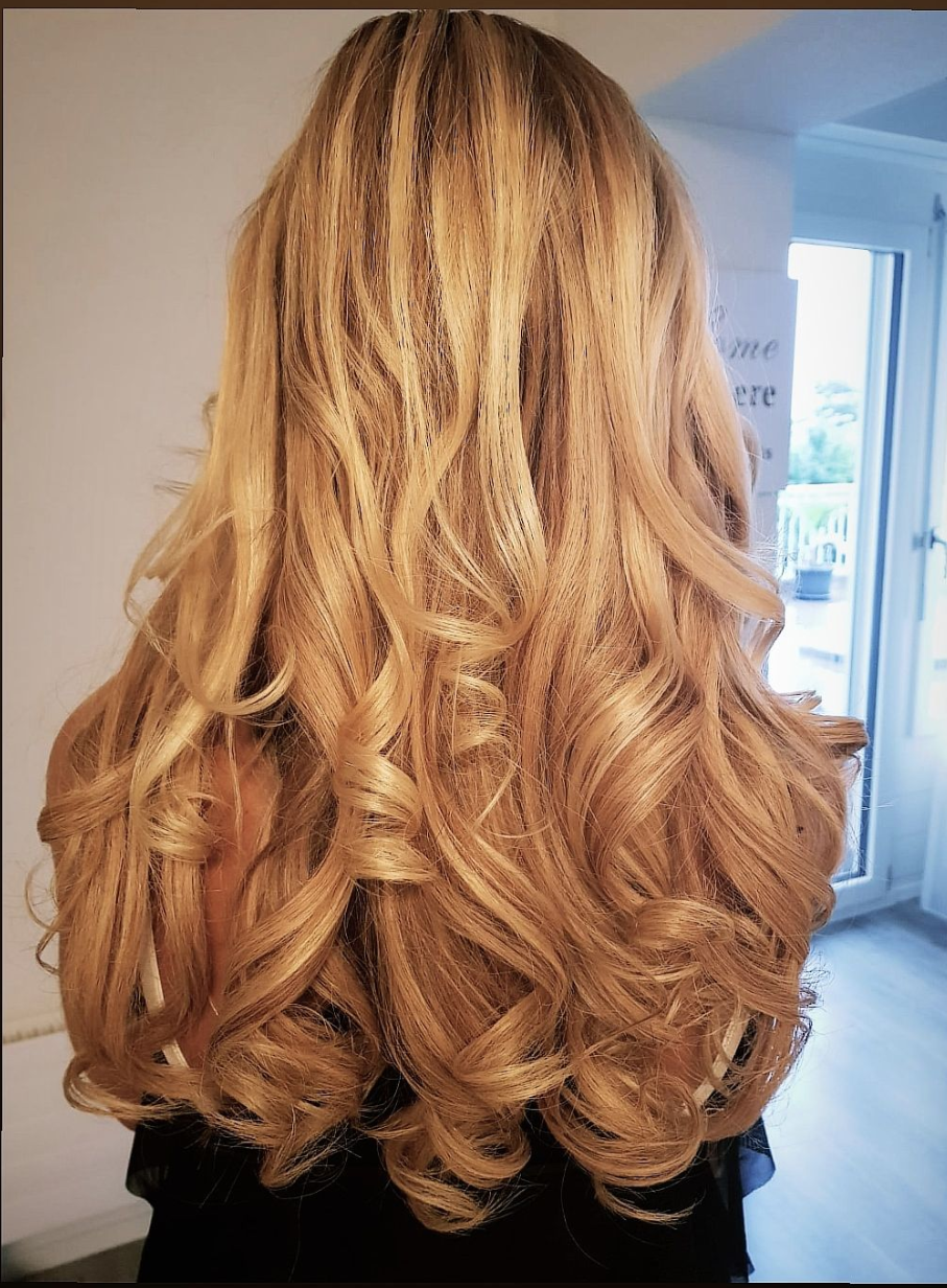 Nahaufnahme von lockigem, blondem Haar in einem gestuften Kurzhaarschnitt.