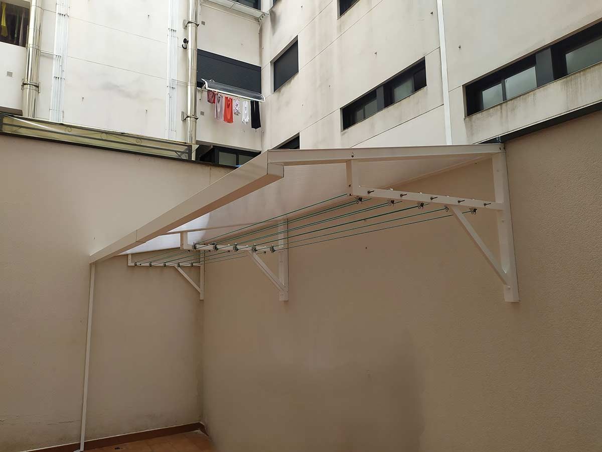 Puerta corrediza de metal marrón con sección superior decorativa, contra un cielo azul.