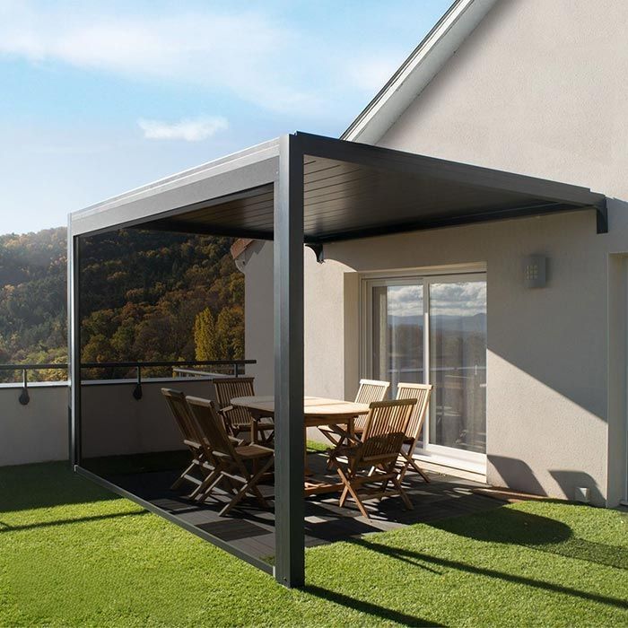 Un moderno patio al aire libre con una pérgola oscura, muebles de madera y césped artificial verde.