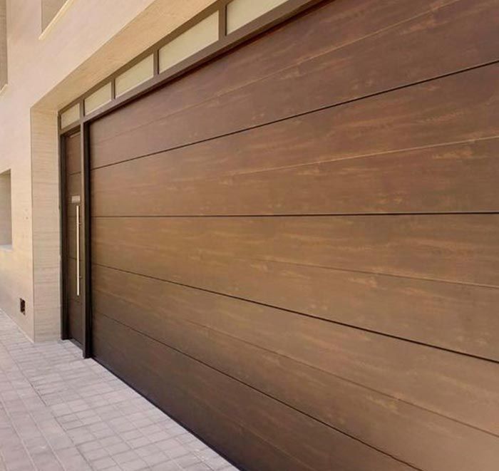 Puerta de garaje de madera marrón con puerta lateral a juego.