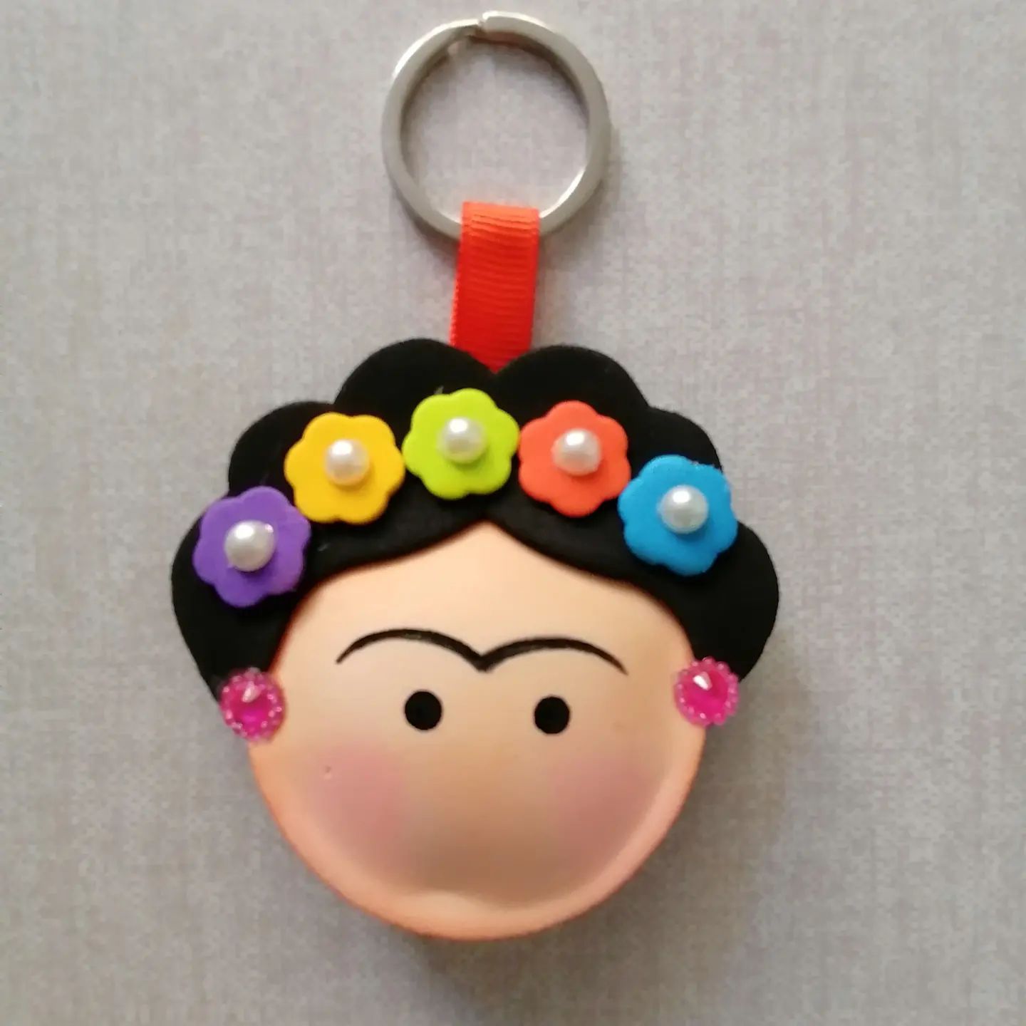 Un llavero de Frida Kahlo con flores en el pelo.