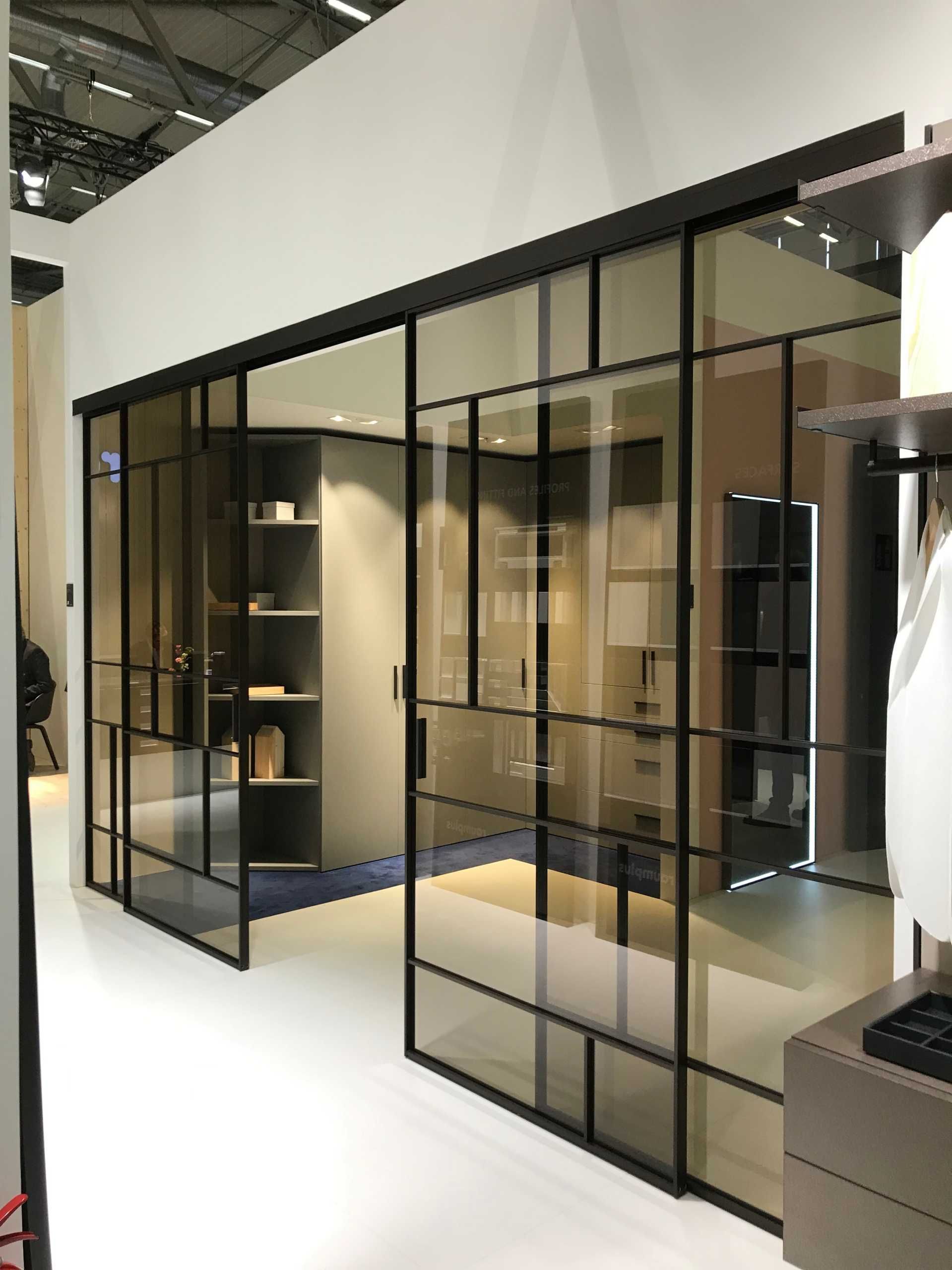 Maßgefertigter Einbauschrank mit offener Regalstruktur und schwarzen Glas-Schiebetüren in modernem Interieur