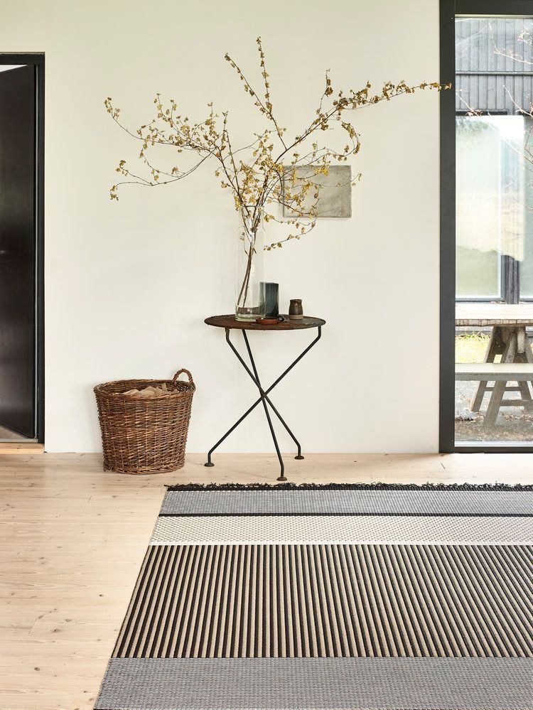 Minimalistischer Eingangsbereich mit Teppich und Korb