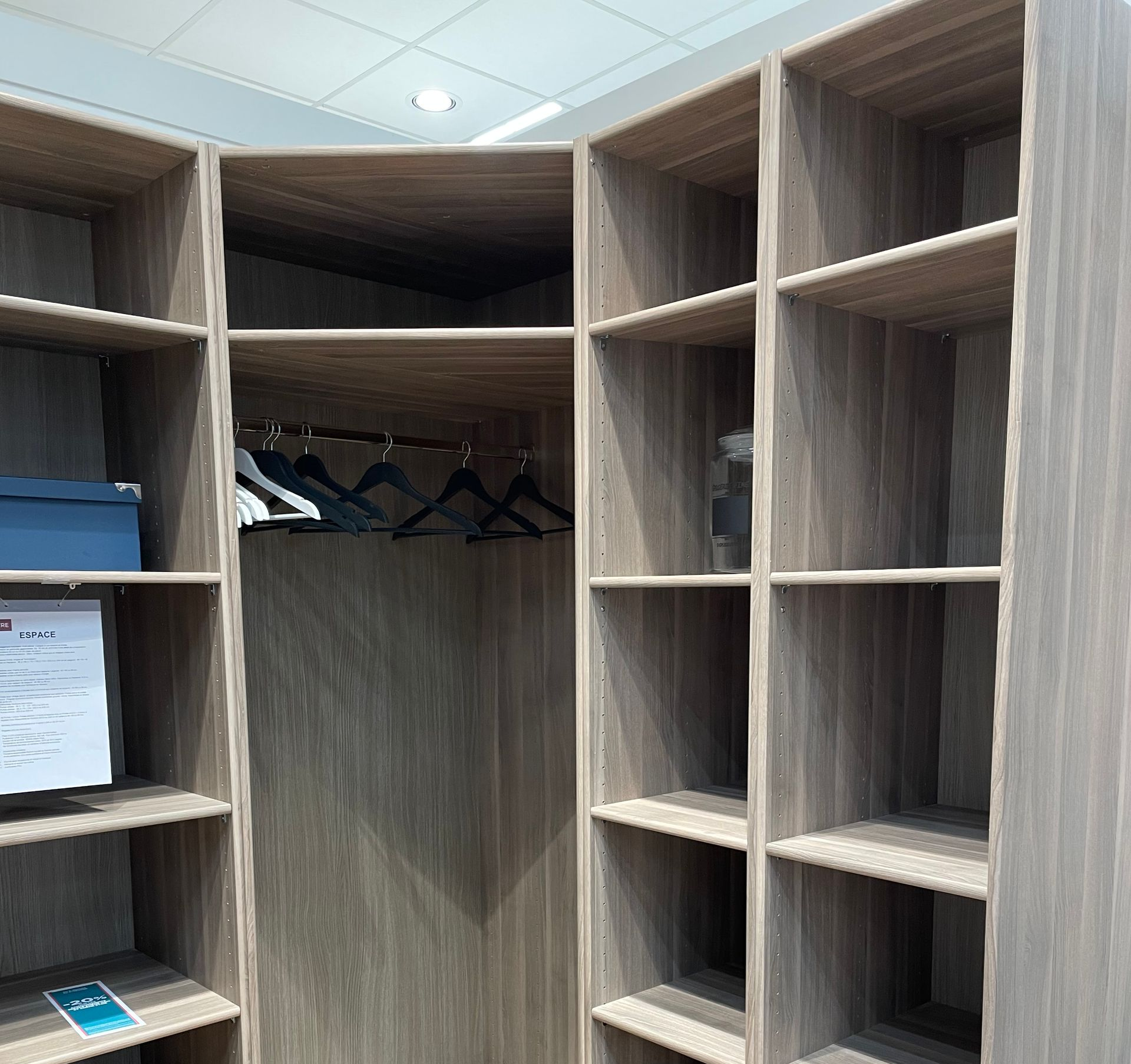 Dressing-room vide avec des étagères et tringle à vêtements, vu depuis l’entrée.