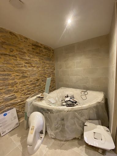 Salle de bains avec du carrelage et des murs en pierre
