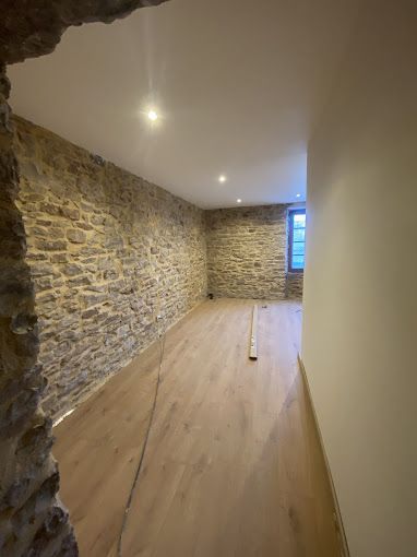 Pièce lumineuse avec du parquet et des murs en pierre