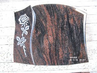 Dunkler Grabstein mit rotem Muster und weißer Gravur einer Rose am linken Rand.