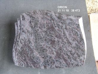 Liegender Grabstein in geschwungener Form mit grauer Oberfläche und rötlicher Struktur.