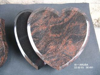 Herzförmiger Grabstein mit auffälliger Rot-Schwarz-Maserung und poliertem Rand.