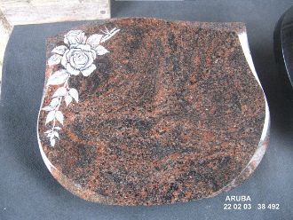 Roter Granitgrabstein mit floralem Relief auf der linken Seite und abgerundeter Oberkante.