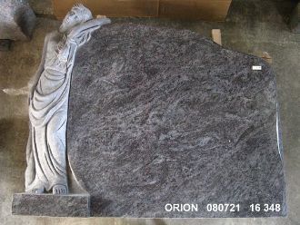 Grabstein aus dunklem Granit mit einer eingravierten Figur einer stehenden Frau in langem Gewand auf der linken Seite