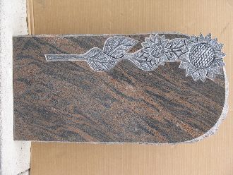 Grabstein aus braunem Granit mit eingravierten Sonnenblumen und Blättern am oberen Rand