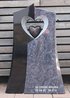 Grabstein aus schwarzem und grauem Stein mit Herzform in der Mitte und Gravur 'IB ORION ARUBA 20 04 20 28 210'