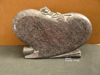 Herzförmiger liegender Grabstein mit Rosenmotiv, polierter Oberfläche und Standfuß.