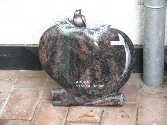 Runder Grabstein mit rötlich-dunkler Maserung und stilisiertem Blattdekor oben.