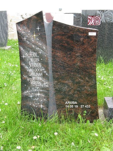 Grabstein aus dunklem Granit mit eingraviertem Text 'Fern bei den Sternen und doch ganz nah bei den Herzen' 