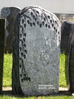 Ein grauer Stein mit einem Blattmuster, das in die Oberfläche geschnitzt ist.