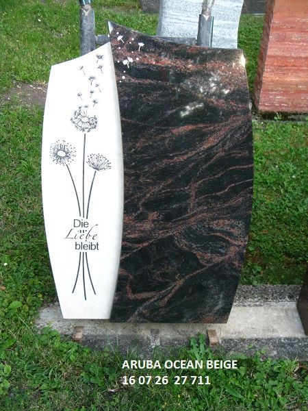 Grabstein aus schwarzem und weißem Stein mit Löwenzahn-Motiv und Schrift 'Die Liebe bleibt'