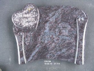 Grabstein aus dunklem Stein mit Herzform links oben, Text im Herz 'Der Himmel hat einen Stern mehr'