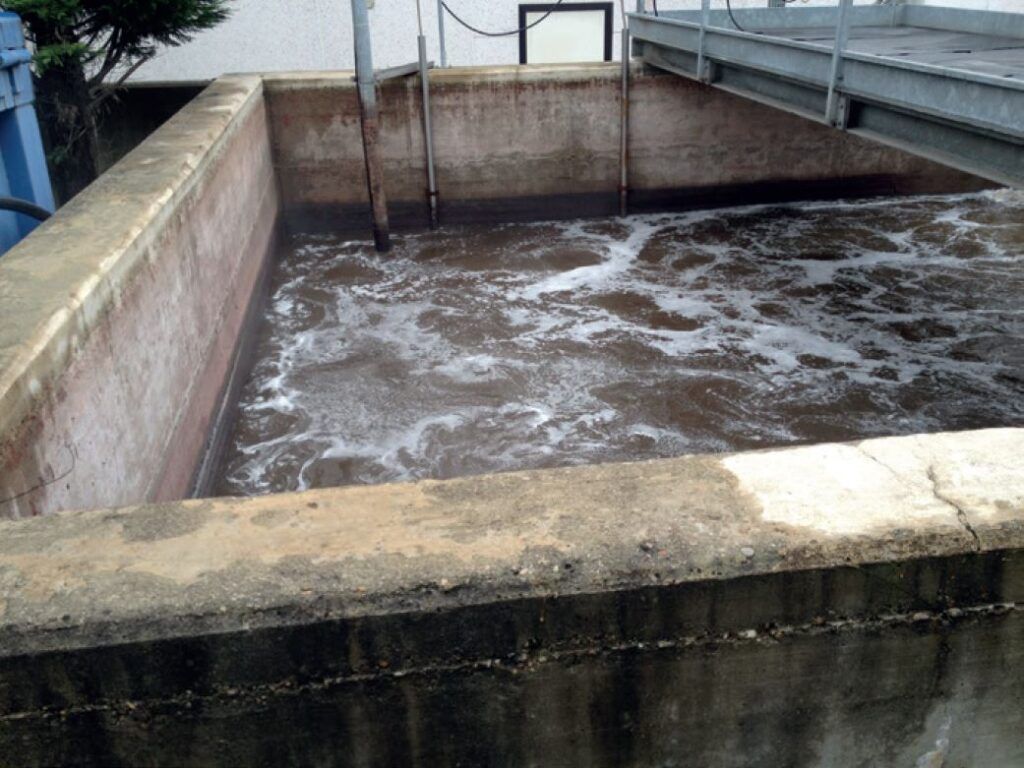 Un gran tanque de hormigón del que sale agua.