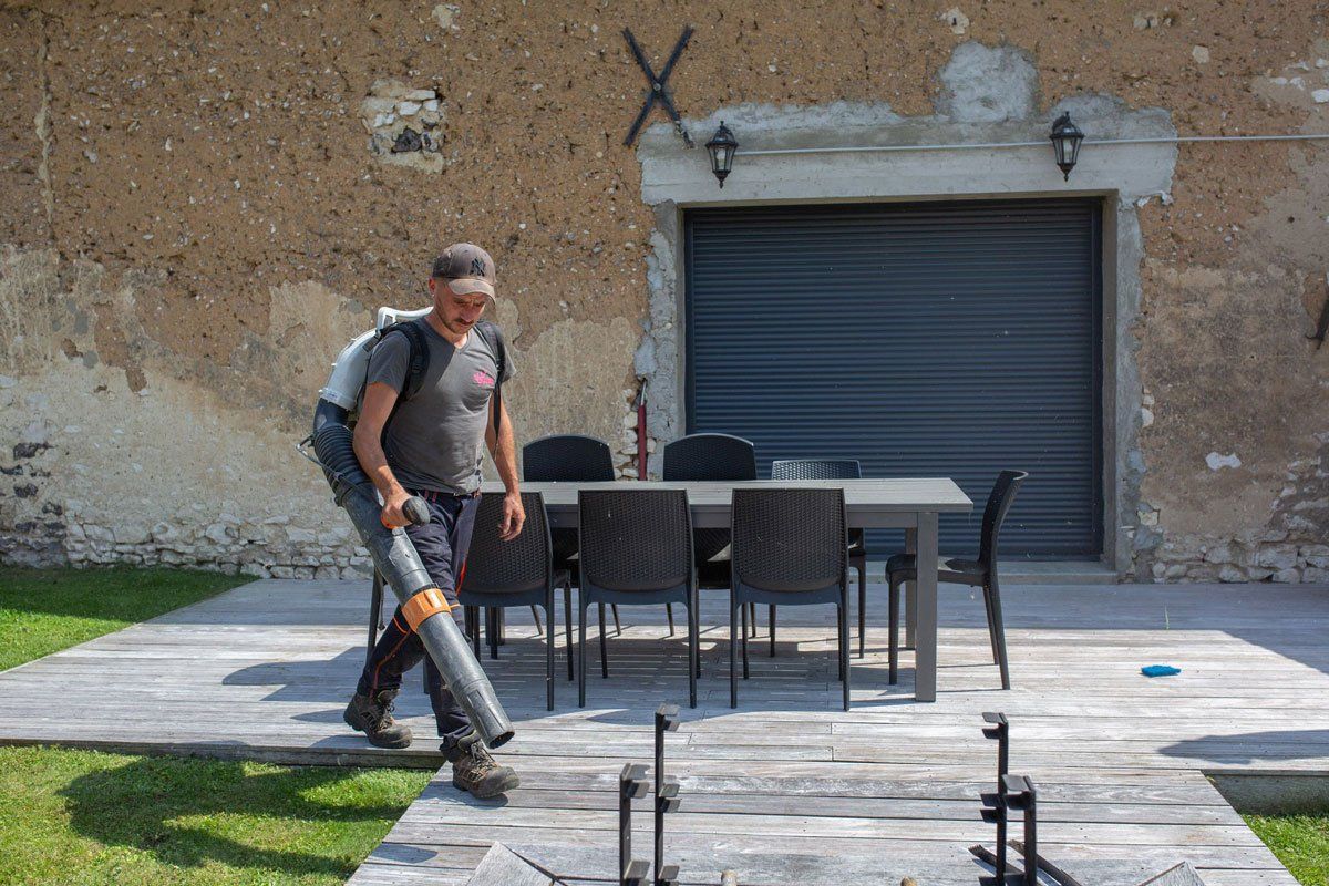 Professionnel passant le souffleur sur une terrasse