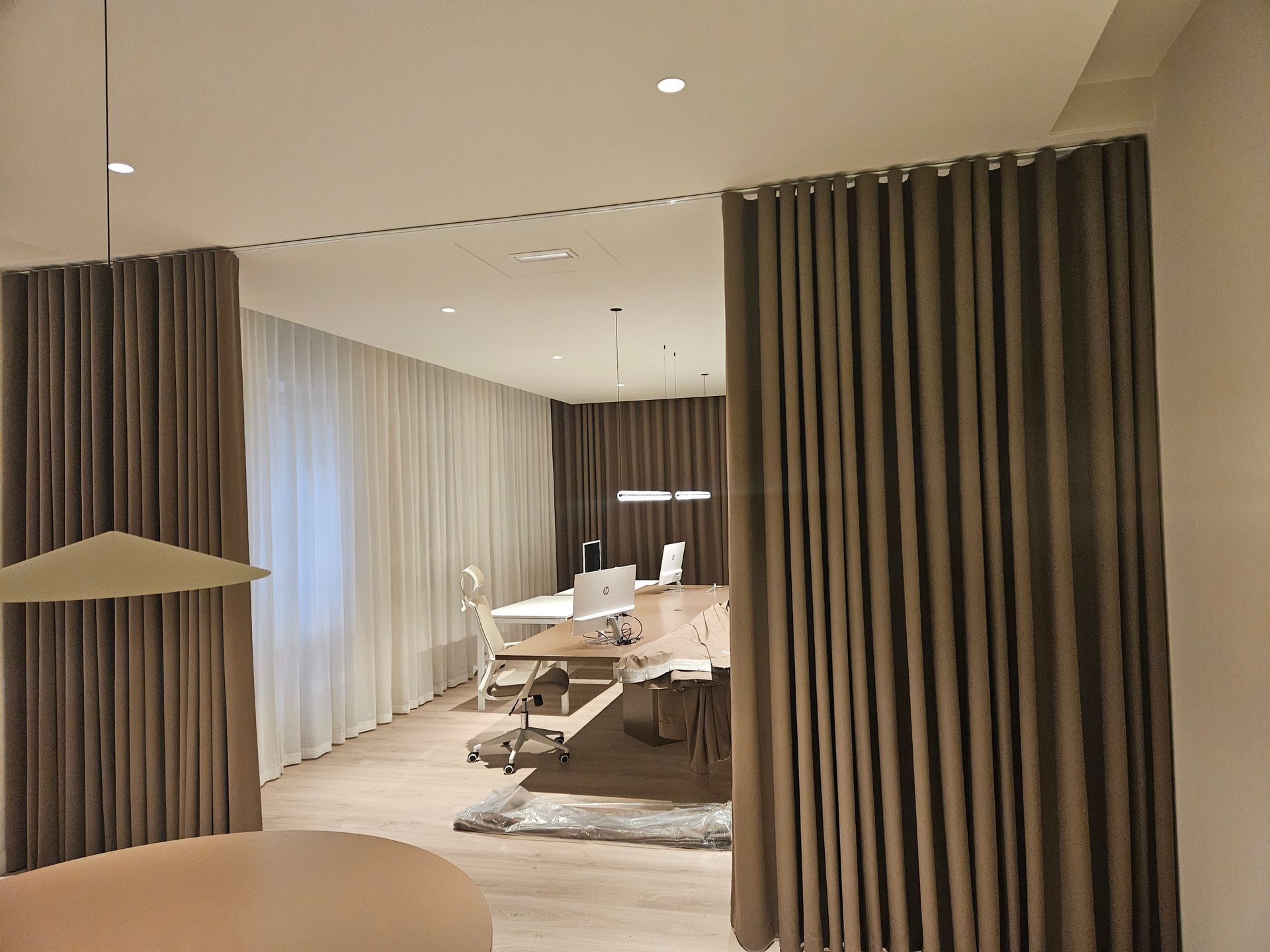 Interior de oficina beige con pesadas cortinas marrones. 