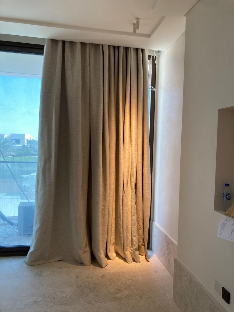 Una habitación con una ventana grande y cortinas.