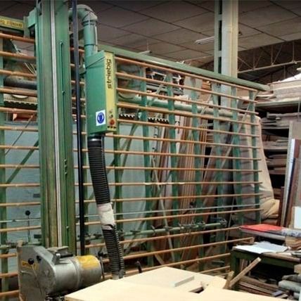 Una sierra de paneles vertical industrial verde en un taller con un sistema de recolección de polvo.