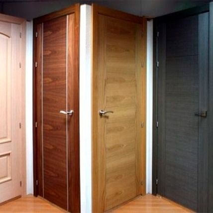 Puertas interiores de madera en varios colores en exposición.