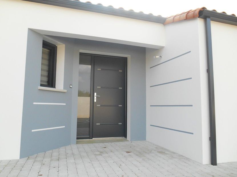 Entrée de maison moderne avec porte d'entrée gris foncé, petite fenêtre et murs extérieurs blancs et gris clair