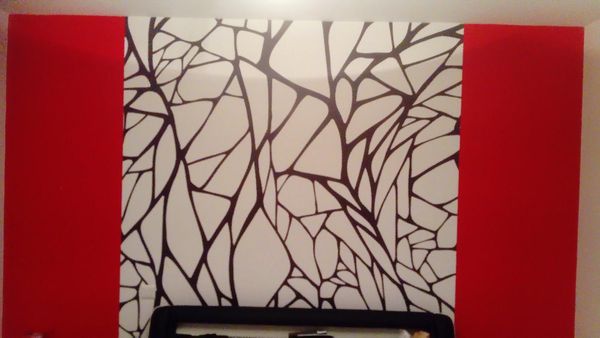Décoration murale abstraite composée de lignes noires ramifiées sur fond blanc, flanquée de deux panneaux verticaux rouges