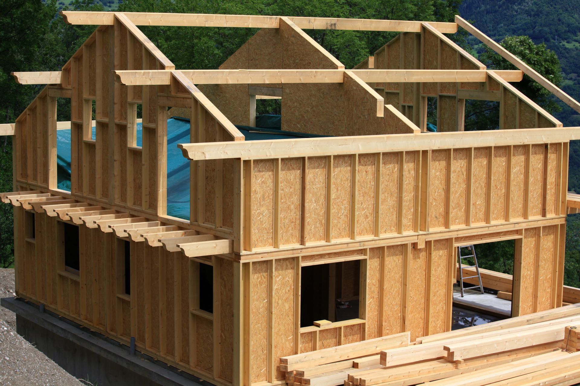 Maison en bois à ossature partielle en construction, avec charpente apparente et murs.