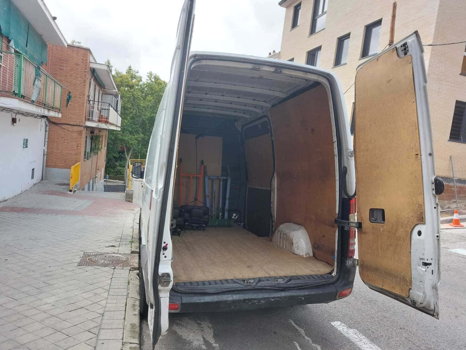 Una camioneta blanca está estacionada al costado de la carretera con la puerta abierta.