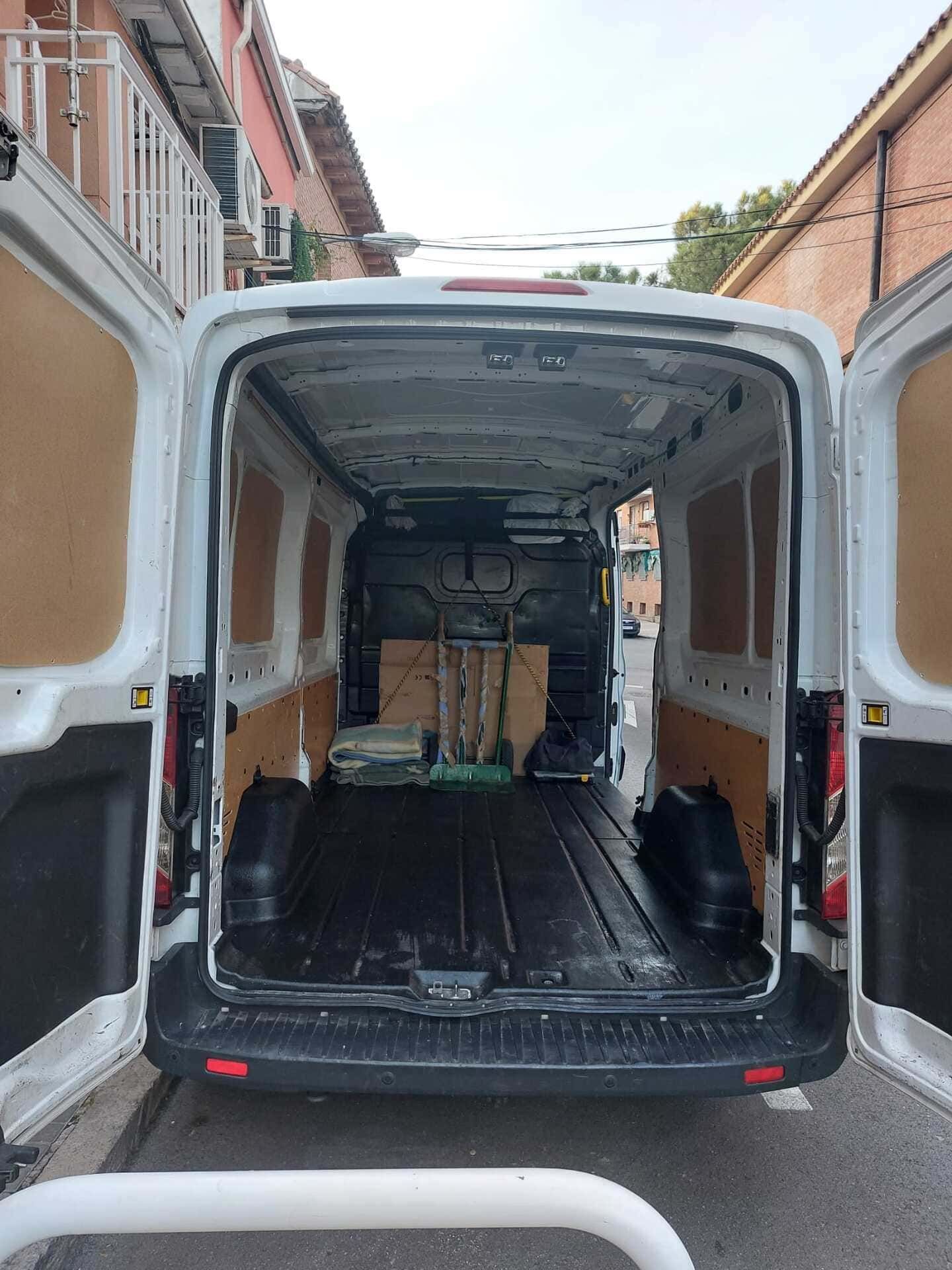 Una camioneta blanca está estacionada al costado de la carretera con las puertas abiertas.