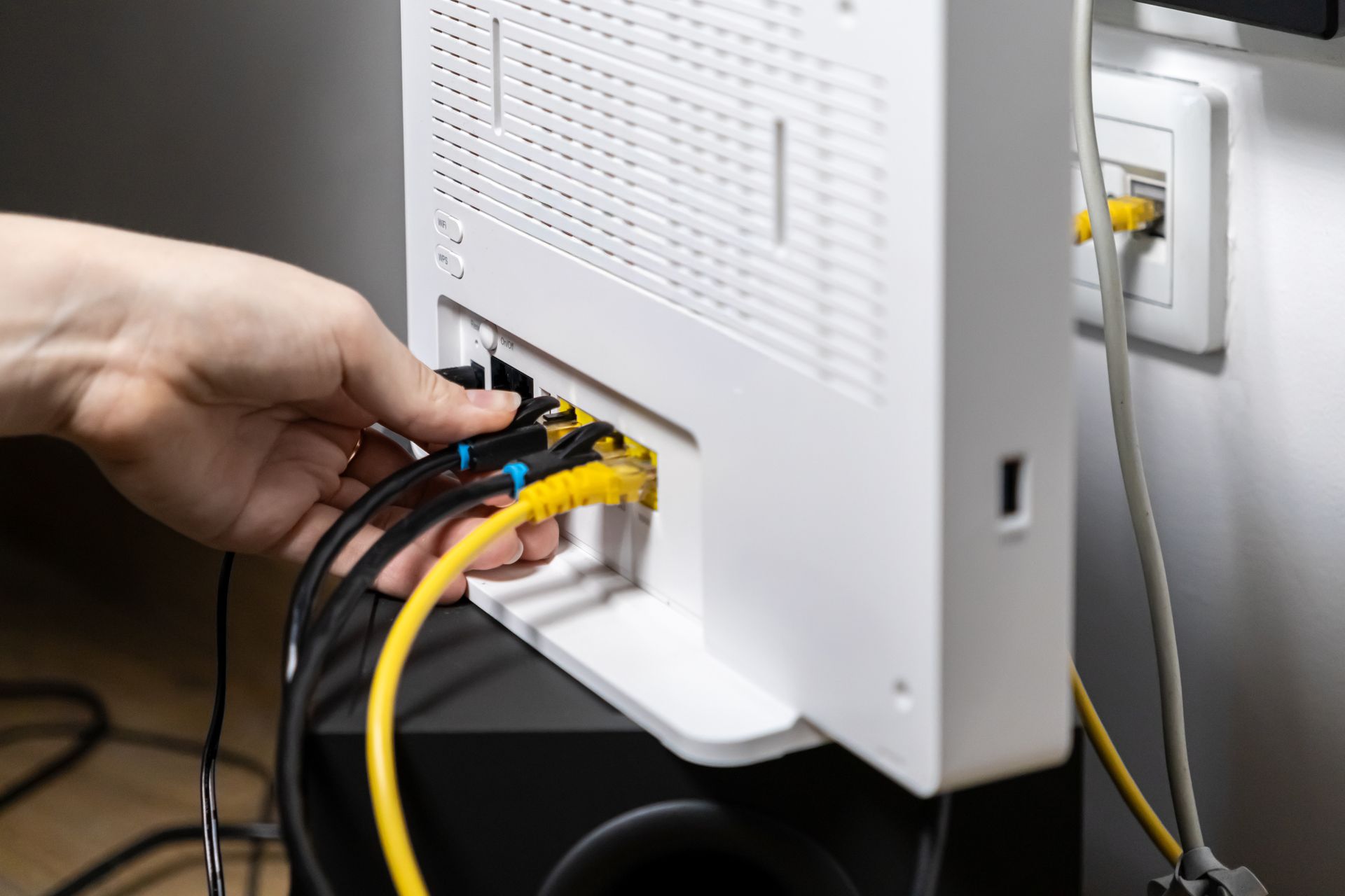 Branchement de câbles éthernet reliant un boîtier internet à une prise murale RJ 45