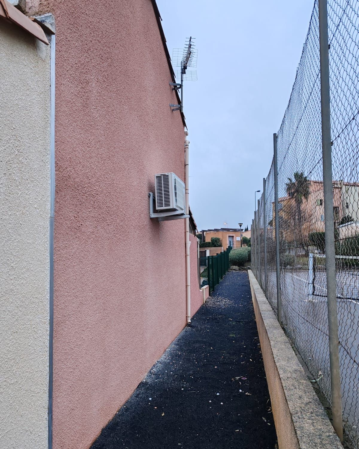 Mur rose avec une unité extérieure de pompe à chaleur