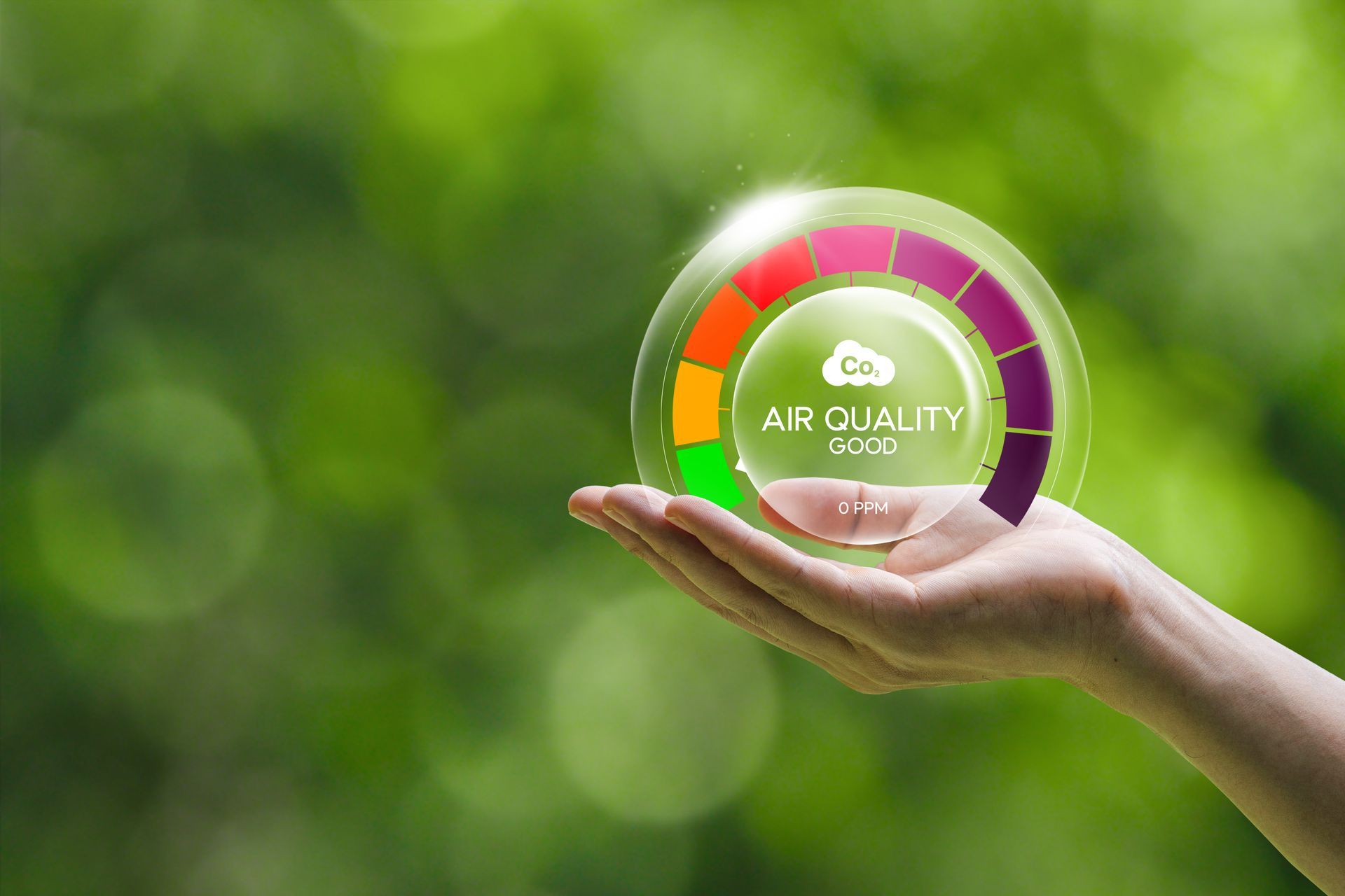 Main tenant une sphère verte lumineuse Qualité de l'air sur un fond vert flou