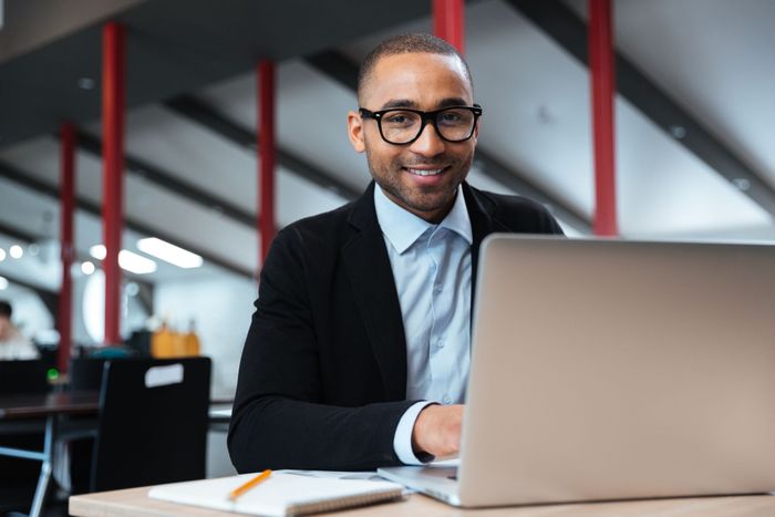 Une personne travaille sur un ordinateur portable à un bureau dans un espace de bureau moderne.