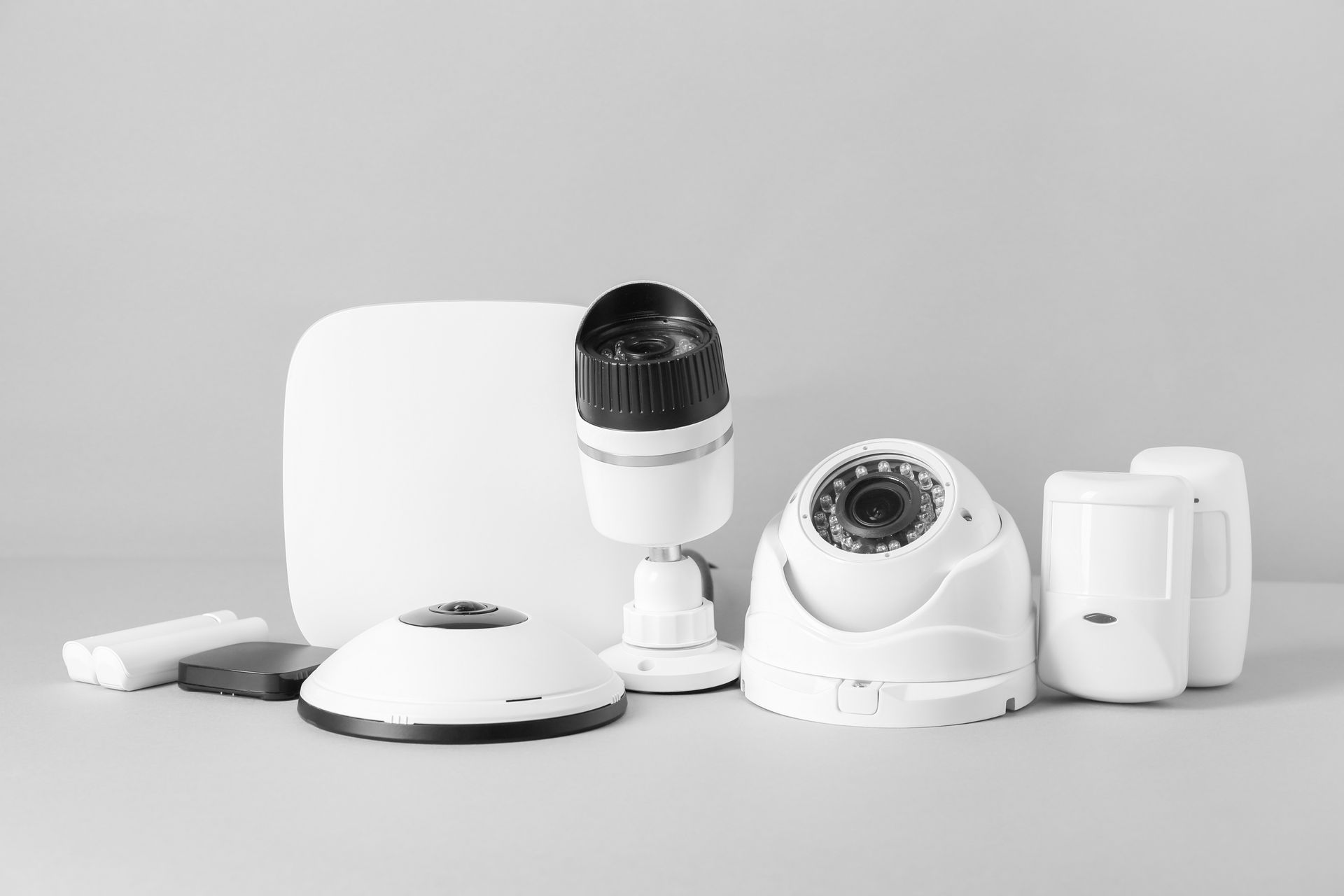 Un ensemble d'équipements de sécurité, comprenant un hub, trois caméras de sécurité et deux détecteurs de mouvement.