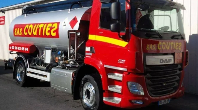 Un camion-citerne DAF rouge, portant l'inscription « SAS COUTIEZ » sur la citerne et la cabine, est stationné à l'extérieur.