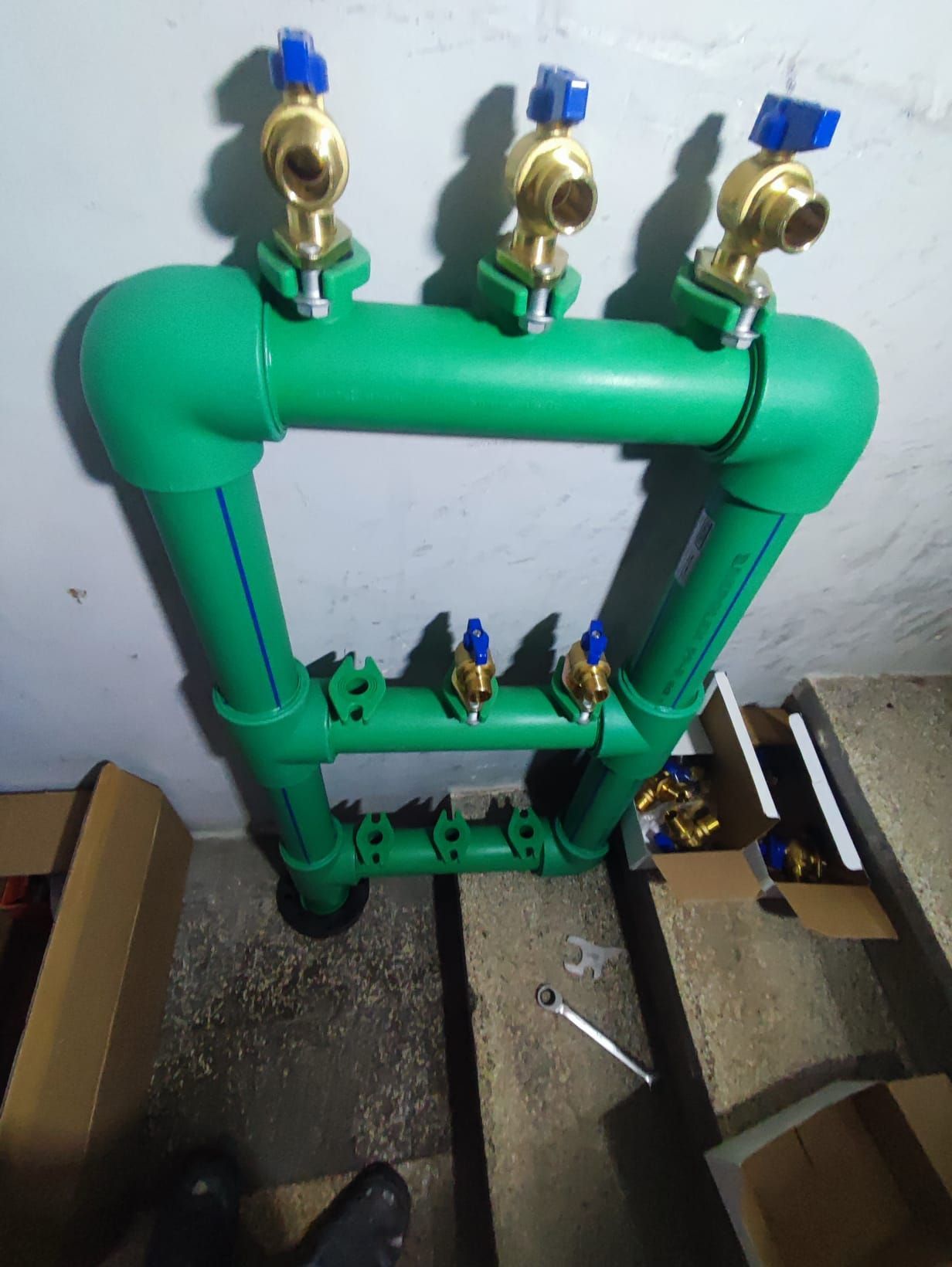 Una tubería verde con válvulas de latón unidas a ella.