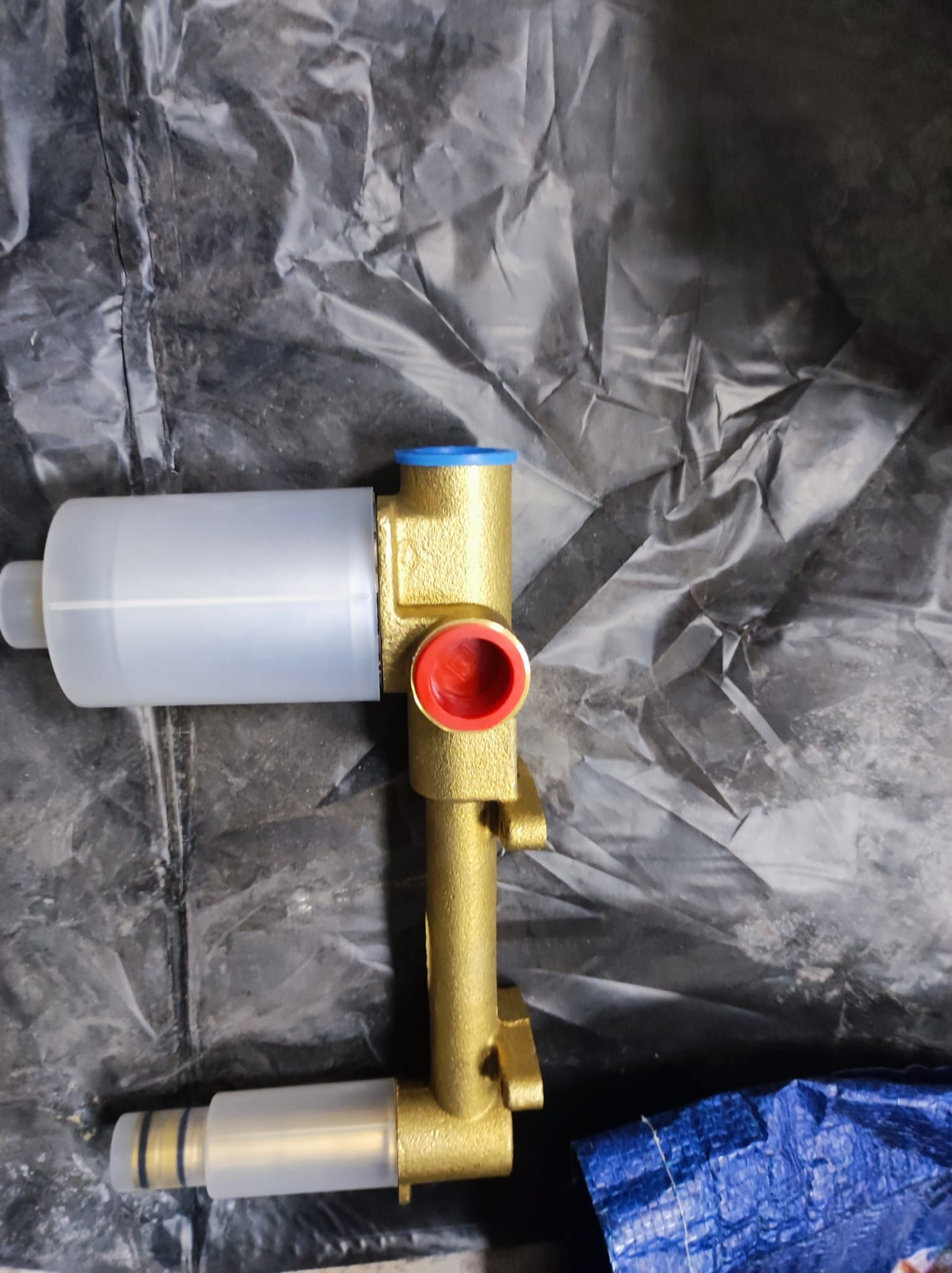 Una válvula de latón está colocada encima de una bolsa de plástico.