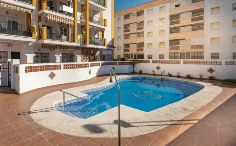 Patio interior del apartamento con una pequeña piscina azul y un patio alicatado a su alrededor.