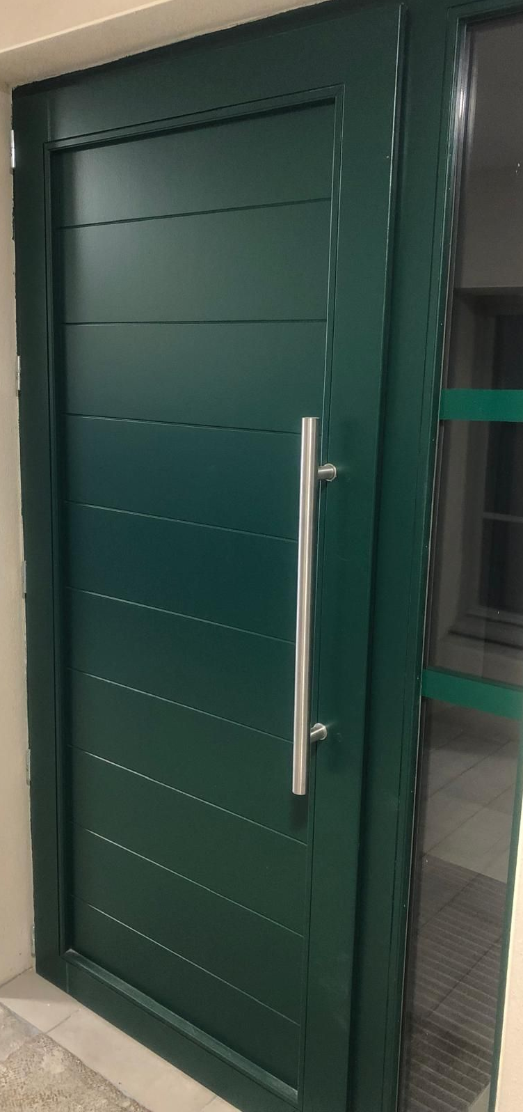 Vers la page Menuiseries Porte extérieure à rayures horizontales et longue poignée.