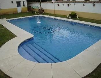 Una gran piscina con escaleras y una fuente en el medio.